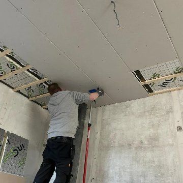 Usta alçıpanlı yalıtımlı bir tavanda çalışıyor